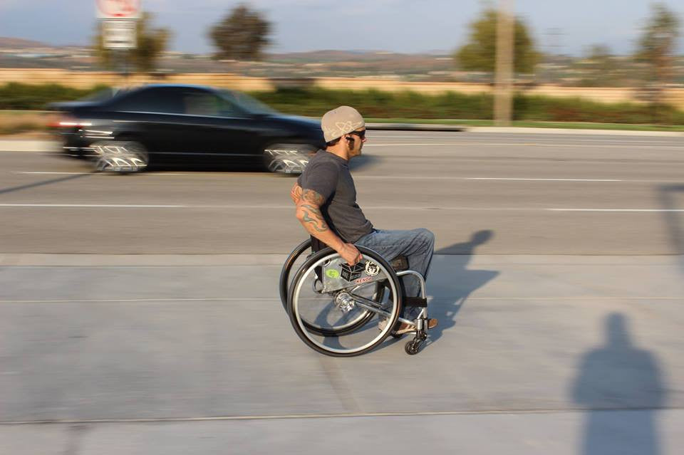Person in wheelchair using Frog Legs Phase 1 Front Suspension Forks Rolling